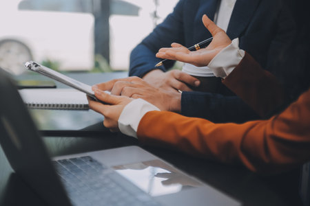 Entrepreneur Asian businessman and businesswoman discussing new business project in tablet in modern Meeting In Modern Office, Asian business casual concept.の写真素材