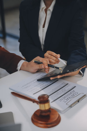Lawyer, legal advisor, businessman brainstorming information on agreement details Business contracts in legal processing books for accuracy in contract documents. joint financial investment.の写真素材