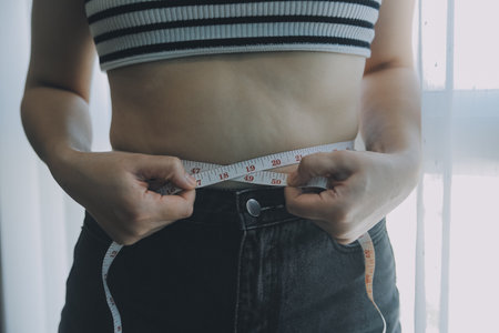 Women body fat belly. Obese woman hand holding excessive belly fat. diet lifestyle concept to reduce belly and shape up healthy stomach muscle.の写真素材