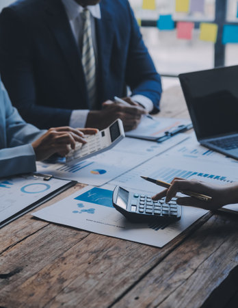 Co working conference, Business team meeting present, investor colleagues discussing new plan financial graph data on office table with laptop and digital tablet, Finance, accounting, investment.の写真素材