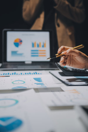 Financial analysts analyze business financial reports on a digital tablet planning investment project during a discussion at a meeting of corporate showing the results of their successful teamwork.の写真素材