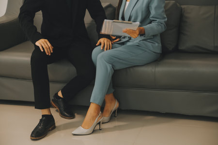 Sexsual harassment in workplace. Unhappy female employee looking at hand of boss touch at her shoulder and feeling disgusted.の写真素材