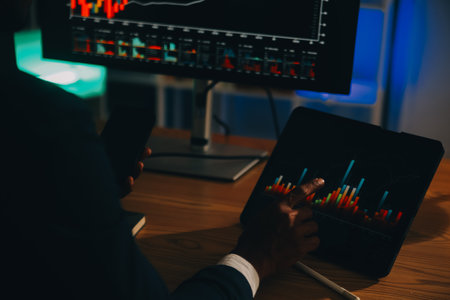 Thoughtful focused successful caucasian male stock investor, broker, financial adviser, sits at work desk, looks at computer, pensively analyze risks and prospects, rise or fall of cryptocurrency coinの写真素材