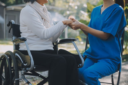 A nurse take care a senior male on wheelchair in his garden at homeの写真素材