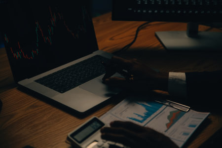 Thoughtful focused successful caucasian male stock investor, broker, financial adviser, sits at work desk, looks at computer, pensively analyze risks and prospects, rise or fall of cryptocurrency coinの写真素材