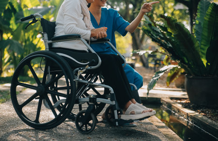 A nurse take care a senior male on wheelchair in his garden at homeの写真素材