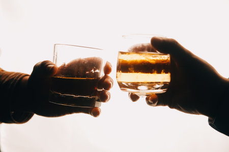 Whiskey splashing out of glass, isolated on white backgroundの写真素材