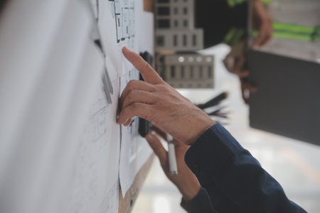 Construction and structure concept of Engineer or architect meeting for project working with partner and engineering tools on model building and blueprint in working site, contract for both companies.の写真素材