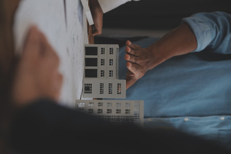 Construction and structure concept of Engineer or architect meeting for project working with partner and engineering tools on model building and blueprint in working site, contract for both companies.の写真素材