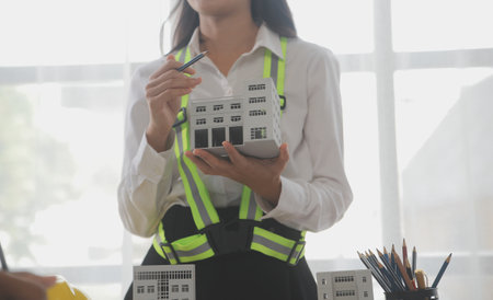 Construction and structure concept of Engineer or architect meeting for project working with partner and engineering tools on model building and blueprint in working site, contract for both companies.の写真素材