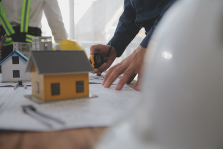 Construction and structure concept of Engineer or architect meeting for project working with partner and engineering tools on model building and blueprint in working site, contract for both companies.の写真素材