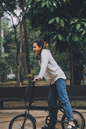 Happy Asian young woman walk and ride bicycle in park, street city her smiling using bike of transportation, ECO friendly, People lifestyle concept.の写真素材