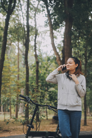 Happy Asian young woman walk and ride bicycle in park, street city her smiling using bike of...
