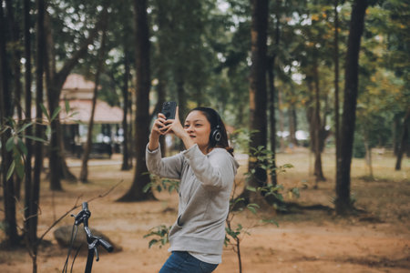 Happy Asian young woman walk and ride bicycle in park, street city her smiling using bike of transportation, ECO friendly, People lifestyle concept.の写真素材
