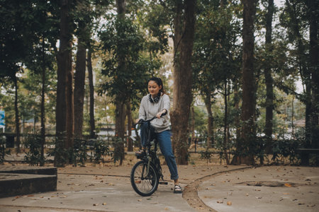 Happy Asian young woman walk and ride bicycle in park, street city her smiling using bike of transportation, ECO friendly, People lifestyle concept.の写真素材