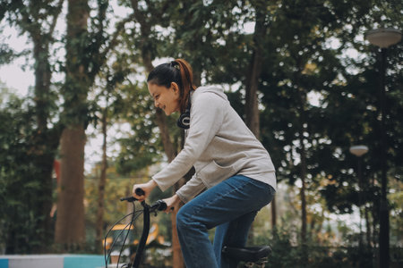 Happy Asian young woman walk and ride bicycle in park, street city her smiling using bike of...