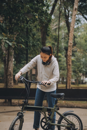 Happy Asian young woman walk and ride bicycle in park, street city her smiling using bike of...