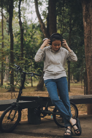 Happy Asian young woman walk and ride bicycle in park, street city her smiling using bike of...