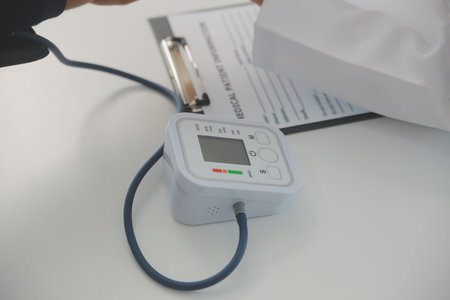 Male doctor uses a blood pressure monitor to check the body pressure and pulse of the patients who...