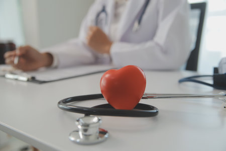 Hands of doctor woman holding red heart, showing symbol of love, human support to patient, promoting medical insurance, early checkup for healthcare, cardiologist help. Close up of objectの写真素材