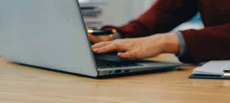 Asian Businesswoman Using laptop computer and working at office with calculator document on desk, doing planning analyzing the financial report, business plan investment, finance analysis concept.の写真素材