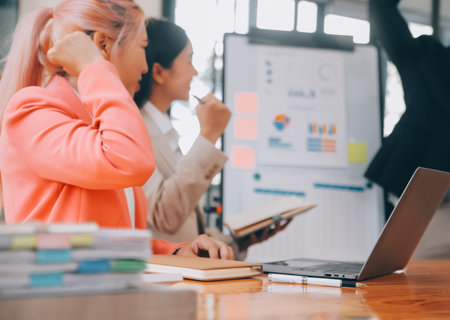 Group of Young Asian business team creative businesspeople coworker in office Happy to be successful partnership teamwork celebrating achievement and success concept.の写真素材