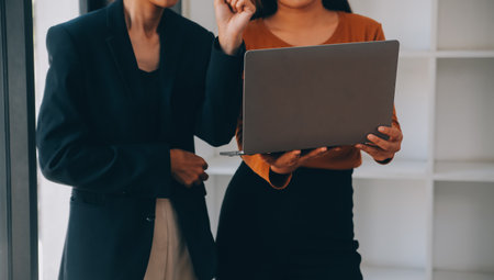 Successful business group are celebrating and looking to digital tablet together at the meeting. People are raising arms.の写真素材