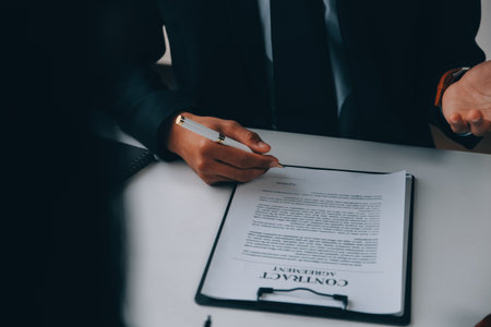 Justice and Law concept. Legal counsel presents to the client a signed contract with gavel and legal law or legal having team meeting at law firm in backgroundの写真素材