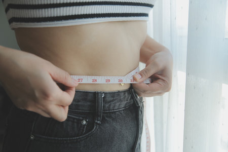 Women body fat belly. Obese woman hand holding excessive belly fat. diet lifestyle concept to reduce belly and shape up healthy stomach muscle.の写真素材