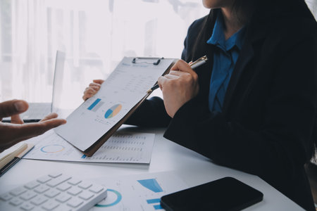 Business team working with new startup project plan and discussion information for financial strategy with laptop and digital tablet in a modern business lounge.の写真素材