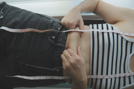 Women body fat belly. Obese woman hand holding excessive belly fat. diet lifestyle concept to reduce belly and shape up healthy stomach muscle.の写真素材
