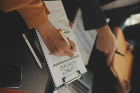 Justice and Law concept. Legal counsel presents to the client a signed contract with gavel and legal law or legal having team meeting at law firm in backgroundの写真素材