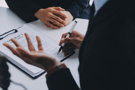 Justice and Law concept. Legal counsel presents to the client a signed contract with gavel and legal law or legal having team meeting at law firm in backgroundの写真素材