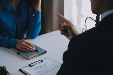 Justice and Law concept. Legal counsel presents to the client a signed contract with gavel and legal law or legal having team meeting at law firm in backgroundの写真素材