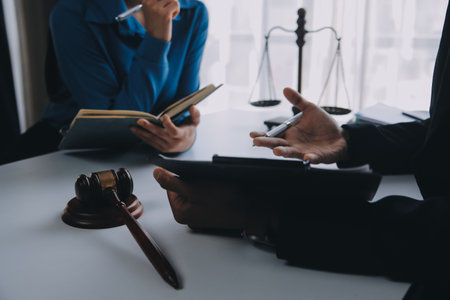 Justice and Law concept. Legal counsel presents to the client a signed contract with gavel and legal law or legal having team meeting at law firm in backgroundの写真素材
