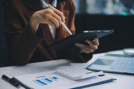 Team work process. young business managers crew working with new startup project. laptop on wood table, typing keyboard, texting message, analyse graph plans.の写真素材