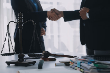 Justice and Law concept. Legal counsel presents to the client a signed contract with gavel and legal law or legal having team meeting at law firm in backgroundの写真素材