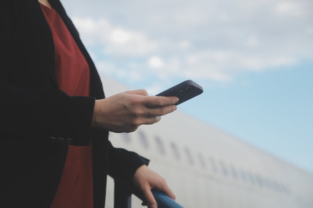 Young asian woman in international airport, using mobile smartphone and checking flight at the...