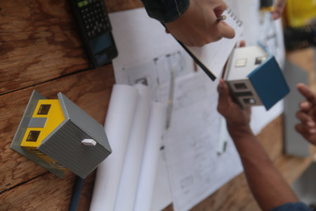 Engineers are consulting the team to design an architectural structure for clients with blueprints...