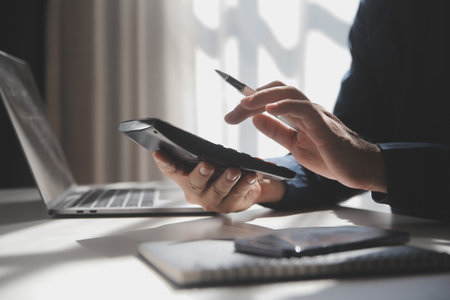 businessman working on desk office with using a calculator to calculate the numbers, finance...