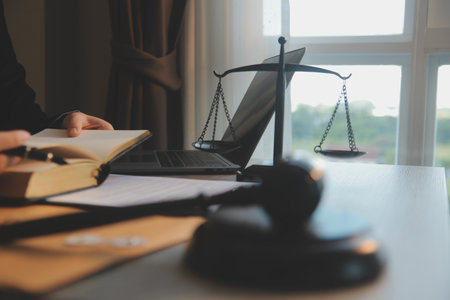 Business and lawyers discussing contract papers with brass scale on desk in office. Law, legal services, advice, justice and law concept picture with film grain effectの写真素材
