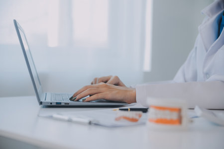 Dentists are discussing dental problems at report x-ray image on laptop screen to patients.の写真素材