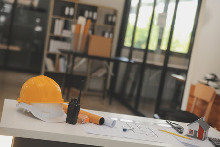 Male and Female Industrial Engineers in Hard Hats Discuss New Project while Using Laptop. They Make Showing Gestures.They Work in a Heavy Industry Manufacturing Factory.の写真素材