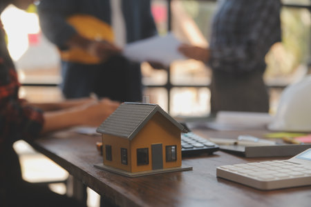 A team of construction engineers talks to managers and construction workers at the construction site. Quality inspection, work plan, home and industrial building design projectの写真素材