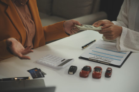 Insurance officers hand over the car keys after the tenant. have signed an auto insurance document...