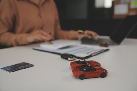 Insurance officers hand over the car keys after the tenant. have signed an auto insurance document or a lease or agreement document Buying or selling a new or used car with a carの写真素材