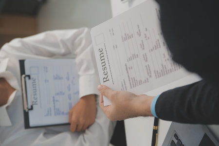 Close up view of job interview in office, focus on resume writing tips, employer reviewing good cv of prepared skilled applicant, recruiter considering application, hr manager making hiring decisionの写真素材