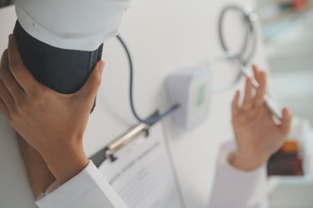 Male doctor uses a blood pressure monitor to check the body pressure and pulse of the patients who...