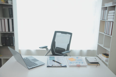 Charming Young asian businesswoman sitting on laptop computer in the office, making report calculating balance Internal Revenue Service checking document.の写真素材