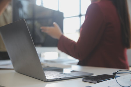 Friendly female helpline operator in call center. Young woman working in call center and holding microphone on headset with hand.の写真素材